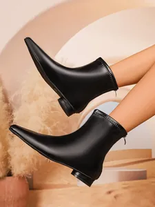 Detailaufnahme von schwarzen elastischen Stiefeletten mit quadratischer Zehenpartie und Blockabsatz.