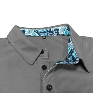 Detail of a grey polo shirt featuring a paisley patterned inner collar and black buttons