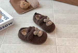 Primo piano di graziose scarpe in peluche marrone per bambini con orecchie di coniglio