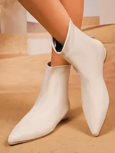 Detailansicht von cremefarbenen elastischen Stiefeletten mit spitzem Zehenbereich