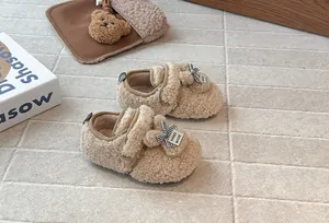 Dettaglio di graziose scarpe in pile per bambine con orecchie di coniglio