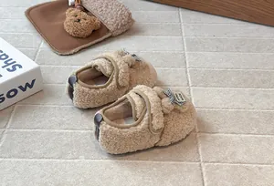 Dettaglio di scarpe calde in pile beige per bambini piccoli con fiocco e velcro