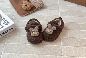 Vista dettagliata di scarpine in peluche marrone per bambini con decorazioni a coniglietto