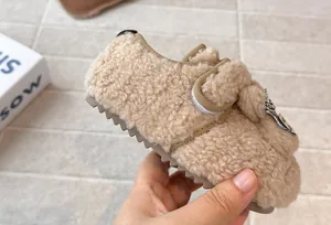 Primo piano di scarpa in cotone beige per neonati con orecchie di coniglio e suola morbida