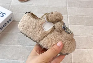 Primo piano di comode pantofole a forma di coniglio in peluche beige per bambini