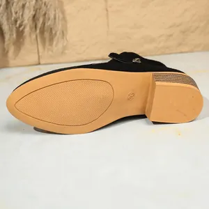 Gedetailleerde weergave van de antislip rubberen zool en de blokhak van een zwarte schoen
