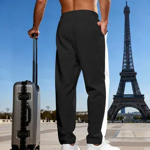 Pantaloni sportivi bicolore uomo bianco e nero con valigia davanti alla Torre Eiffel