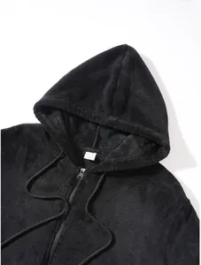 Close-up of a black plush zip-up hoodie showing the hood and collar label detail.