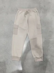 Dettaglio dei pantaloni cargo uomo beige in pesante tessuto waffle con coulisse regolabile