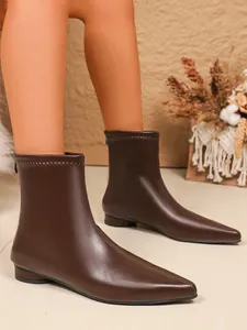 Nahaufnahme brauner elastischer Stiefeletten mit spitzer Kappe und feinen Nähten