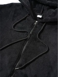 Close-up detail of a soft black fuzzy fleece hoodie with zipper and drawstring texture