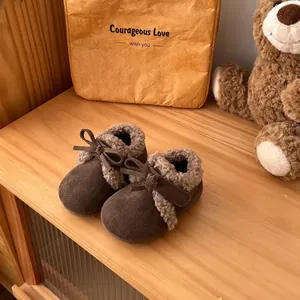 Primer plano de zapatos de invierno para niños marrones con forro de felpa y lazo