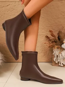 Detailansicht brauner flacher Stiefeletten mit spitzer Zehenpartie und Stretchschaft.