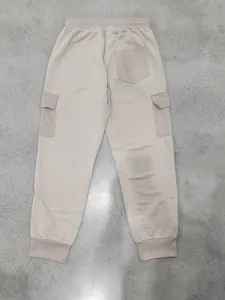Dettaglio della vista posteriore di pantaloni cargo beige con tasca e trama a nido d'ape