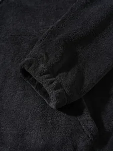 Detail view of black fleece sweatshirt cuff showcasing soft plush fabric and elastic finish