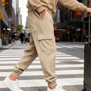 Dettaglio dei pantaloni cargo pesanti in jacquard beige da uomo in ambiente urbano