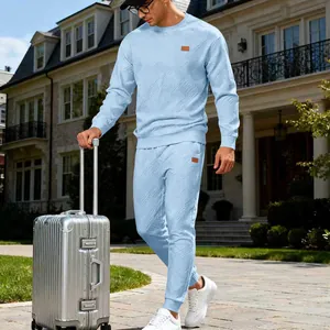 Detail shot of light blue jacquard men's tracksuit set in a travel lifestyle scene