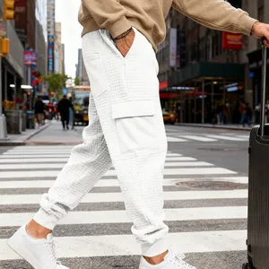 Dettaglio dei pantaloni cargo in jacquard bianco da uomo con tasca laterale e polsini a coste