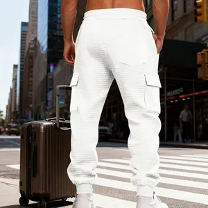 Dettaglio dei pantaloni cargo bianchi pesanti da uomo con trama jacquard e tasche.