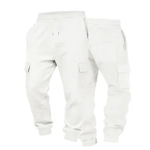 Dettaglio dei pantaloni cargo bianchi da uomo con pesante trama a nido d'ape.