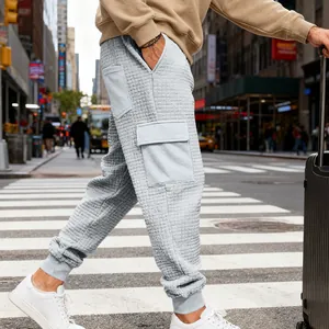 Dettaglio della trama jacquard grigia e della tasca cargo sui pantaloni sportivi uomo