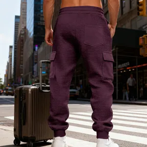 Vista dettagliata della pesante trama jacquard su questi pantaloni cargo viola da uomo