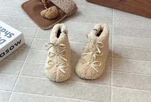 Dettaglio con tre graziosi fiocchi su stivali Lolita invernali in pile beige per bambine