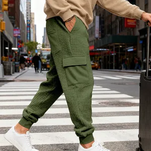 Vista dettagliata dei pantaloni cargo da uomo verde oliva testurizzati con tasche