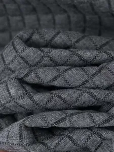Close-up detail of grey diamond-patterned fleece fabric for men's winter jacket
