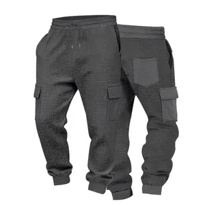 Vista dettagliata dei pantaloni cargo jogger in maglia a nido d'ape grigio scuro