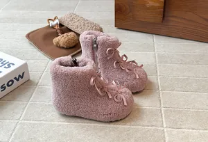 Dettaglio di stivaletti Lolita in peluche rosa per bambina con fiocchi e zip laterale