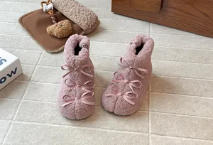 Dettaglio degli stivaletti invernali in peluche rosa per bambine con tripli fiocchi in nastro