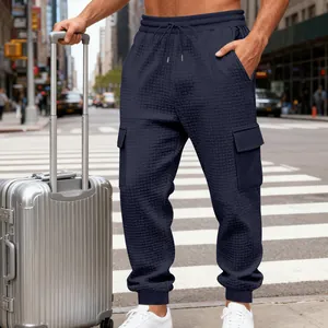 Dettaglio dei pantaloni cargo blu navy testurizzati con coulisse in vita