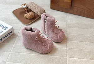 Dettaglio di stivaletti in peluche rosa per bambine con eleganti fiocchi e fodera