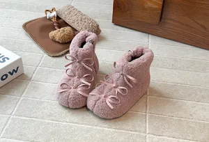 Dettaglio di stivali invernali rosa pelosi per bambine con fiocchi di raso satinato