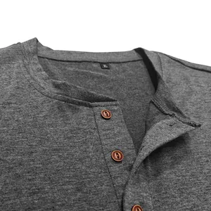 Close-up of men's dark grey heathered Henley shirt neckline featuring brown buttons
