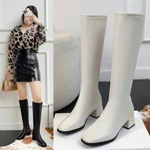 Close-up detail of off-white knee-high knight boots featuring a square toe and block heel