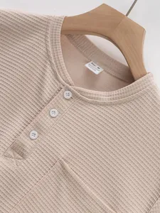 Detail shot of men's beige waffle knit Henley shirt showing button placket and texture