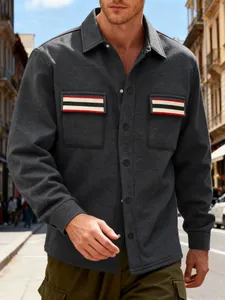 Détail d'une veste de travail grise pour homme avec poches à rayures rouges et blanches.