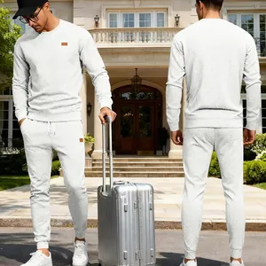 Men's white jacquard knit sweatshirt and pants tracksuit set shown in travel setting