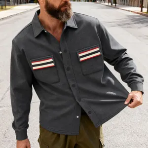 Détail d'une veste de travail grise pour homme avec poches poitrine contrastées.