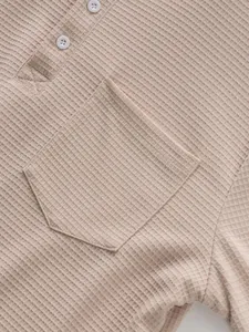 Close-up detail of waffle knit texture on men's beige Henley shirt with chest pocket