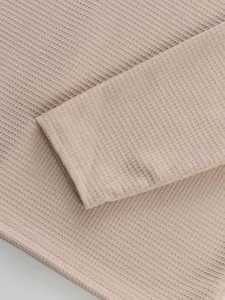 Close-up of beige waffle knit fabric texture on men's casual long sleeve shirt