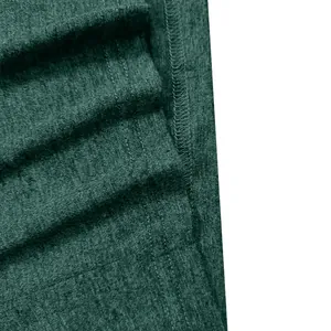 Close-up of the breathable green fabric texture and neat stitching of a men's shirt.