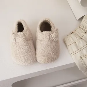 Sabots douillets en laine d'agneau beige avec bride réglable pour l'automne et l'hiver.