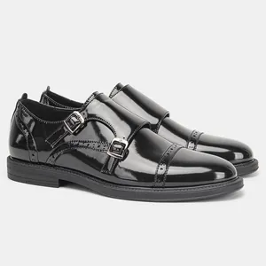 Dettaglio delle scarpe monk strap doppie in pelle verniciata nera con intagli