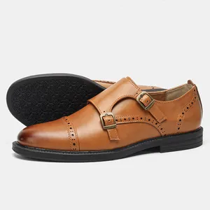 Dettaglio di scarpe monk strap in pelle marrone con brogue e suola in gomma antiscivolo.