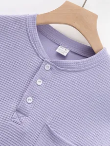 Close-up detail of a lavender ribbed Henley shirt featuring white buttons and size label