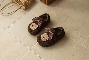 Detailansicht warmer Winter-Babyschuhe mit flauschigem braunem Fleece und Bärenaufnäher