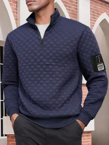 Dettaglio della felpa blu navy da uomo con collo alto e texture a quadri trapuntata.
